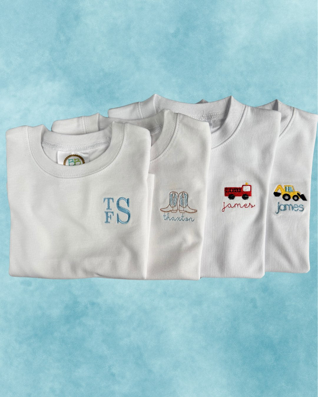 Personalized white tees — monogram, cowboy boots, firetruck, and excavator motifs embroidered with names